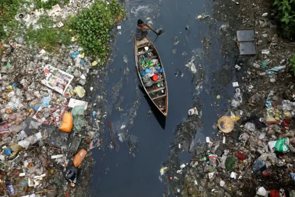 imagenes de la contaminacion del agua hombre navega por rio contaminado con basura local